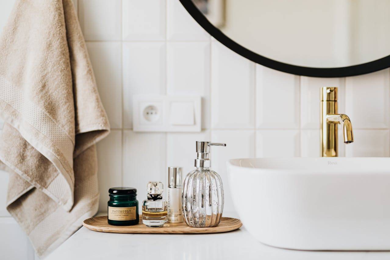 Bathroom with plumbing fixture, tap, mirror, soap dispenser, sink, bottle, and a mysterious message "FATCHOULI Rea".